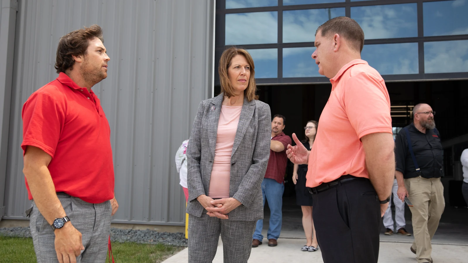 Officials and training-school staff talk outside a line-constructor apprenticeship facility in Iowa.