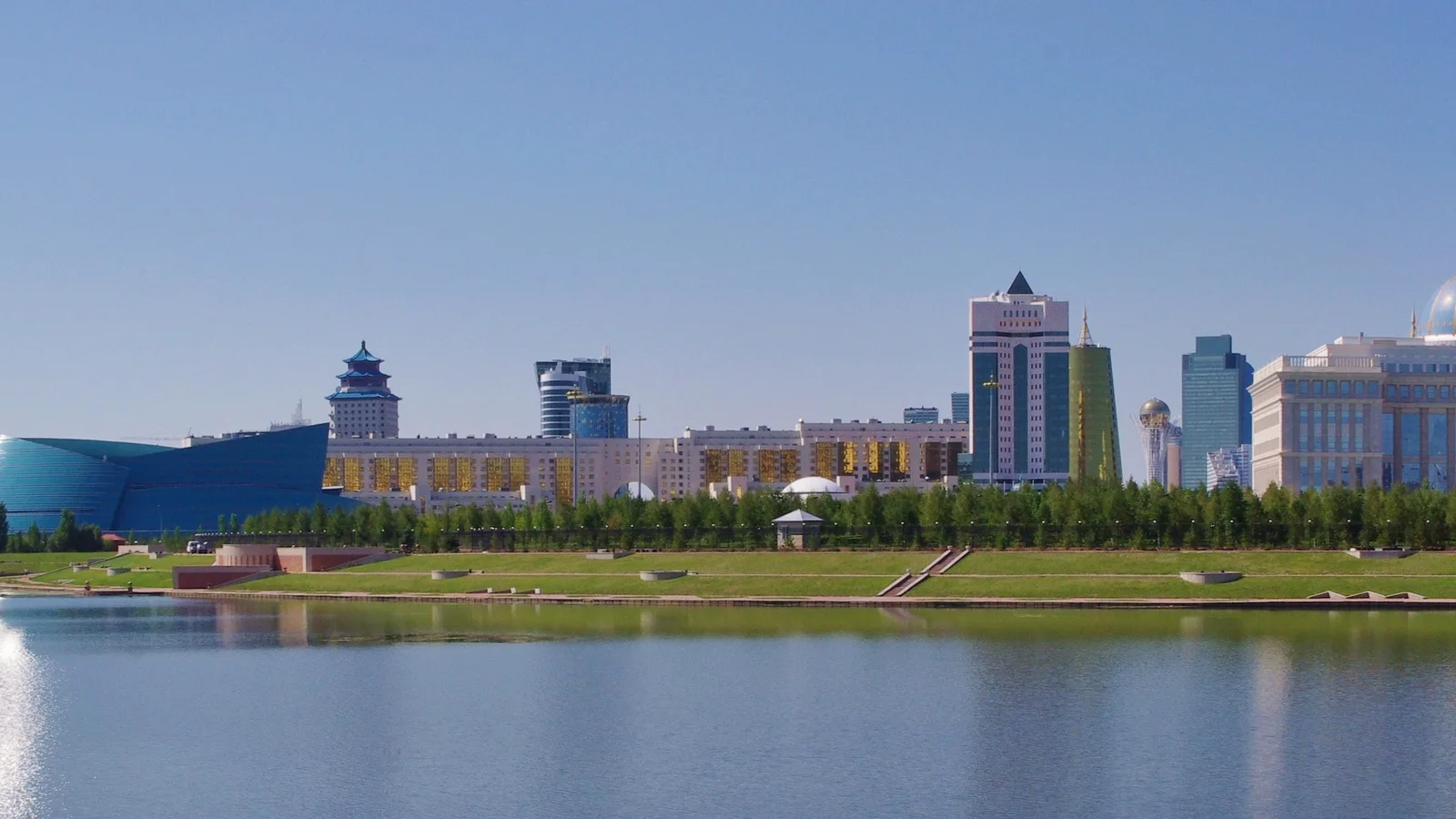 Wide panorama of modern towers and government buildings along the Astana skyline.