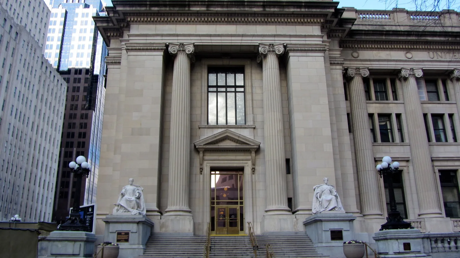 A historic stone federal courthouse rises above a downtown Indianapolis street.