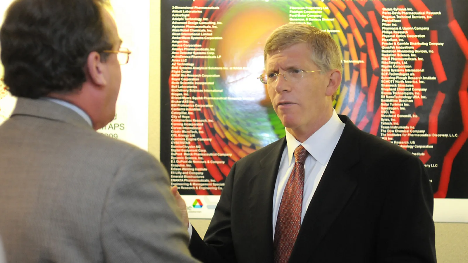 Researchers and officials stand beside equipment inside the Advanced Photon Source.